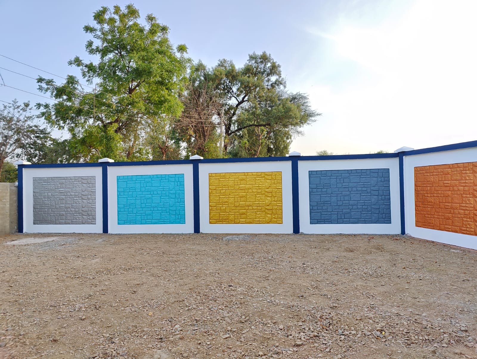 Corner compound wall showing yellow, blue, orange and green colour finish panels