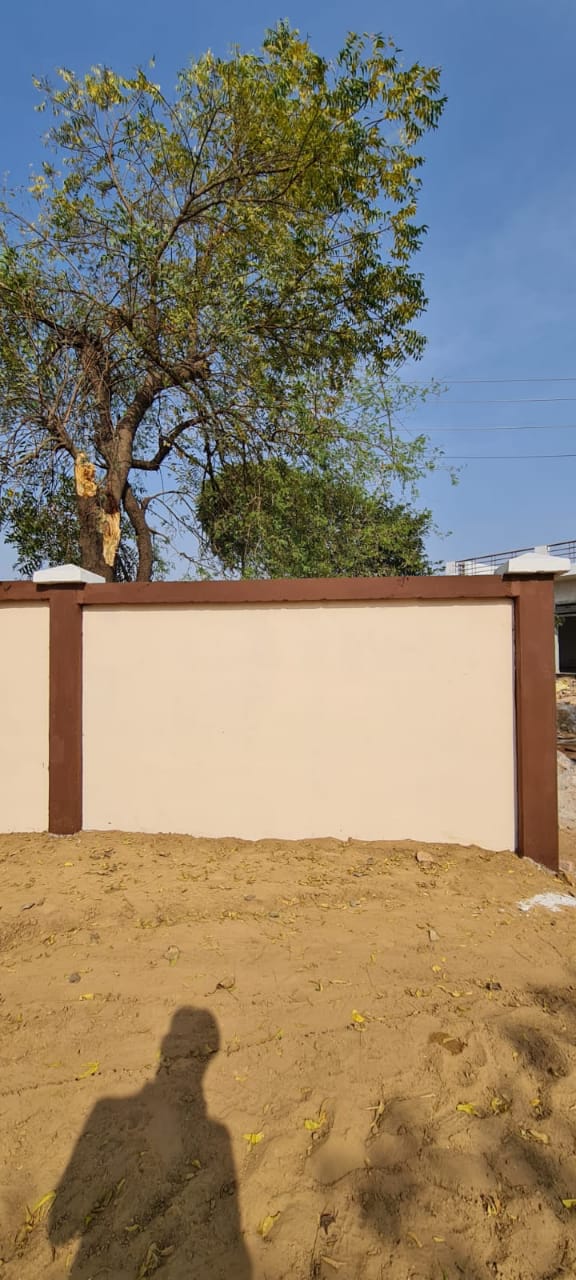 Compound wall painted in cream finish with brown pillar trim