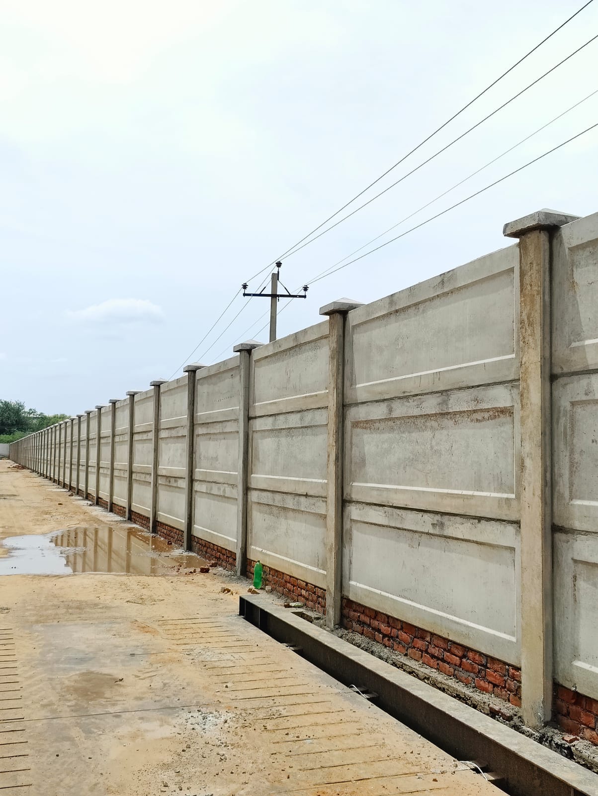 Precast compound wall fitted with barbed wire security topper