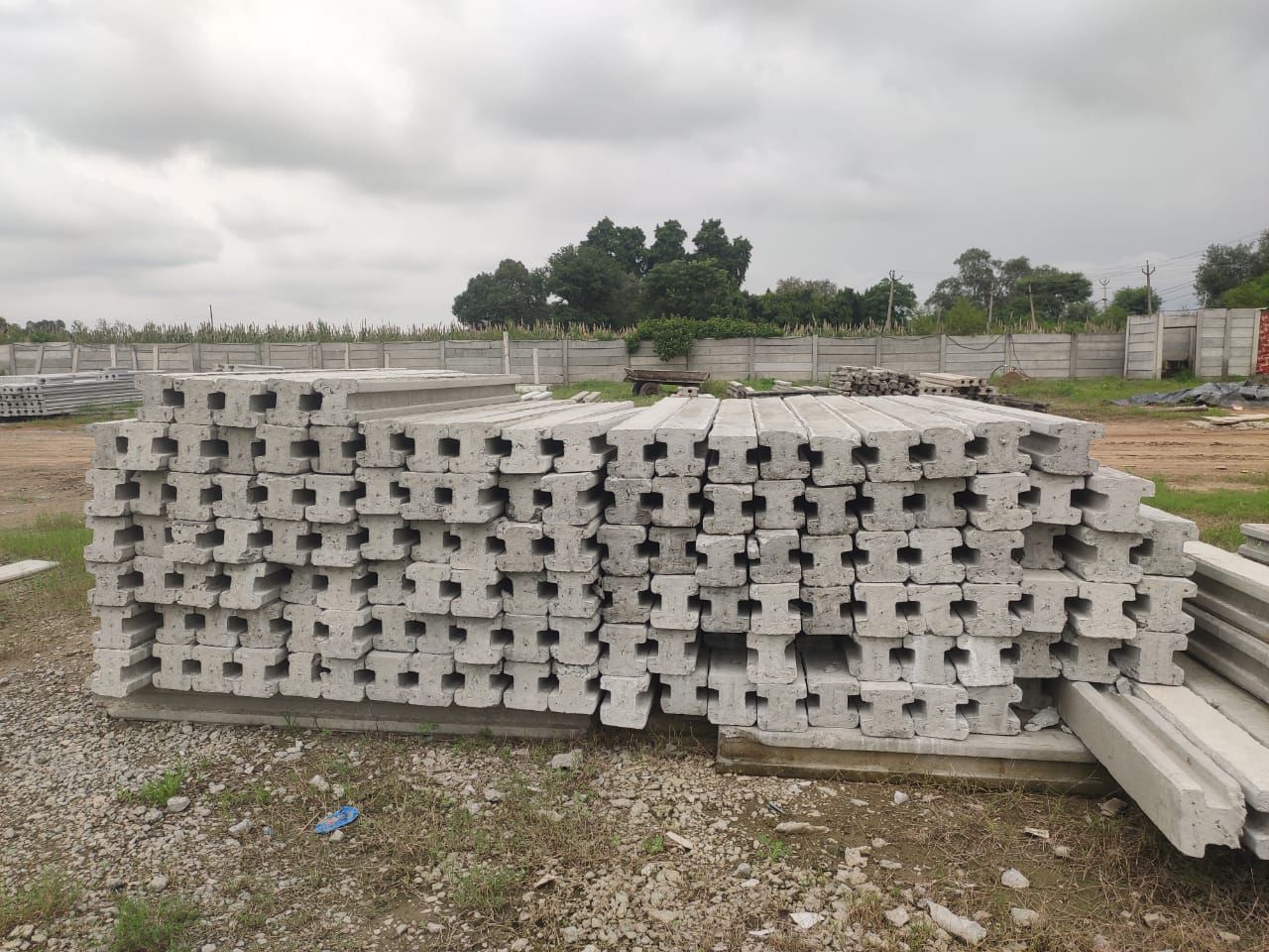 Stacked RCC columns showing steel wire holes at the yard