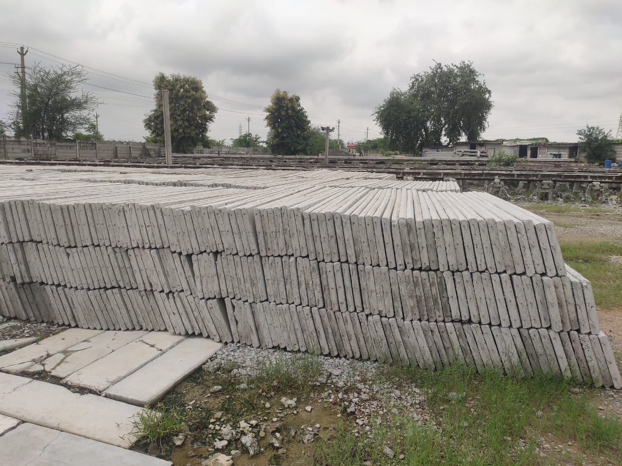 Long rows of stacked RCC fencing posts at the casting yard